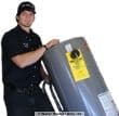 water-heater-installation-technician-bringning-in-new-water-heater Water heater installation technician bringing in new water heater